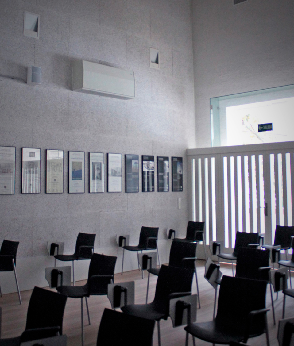 Imagen de una sala con varias sillas y varios cuadros colgados en la pared